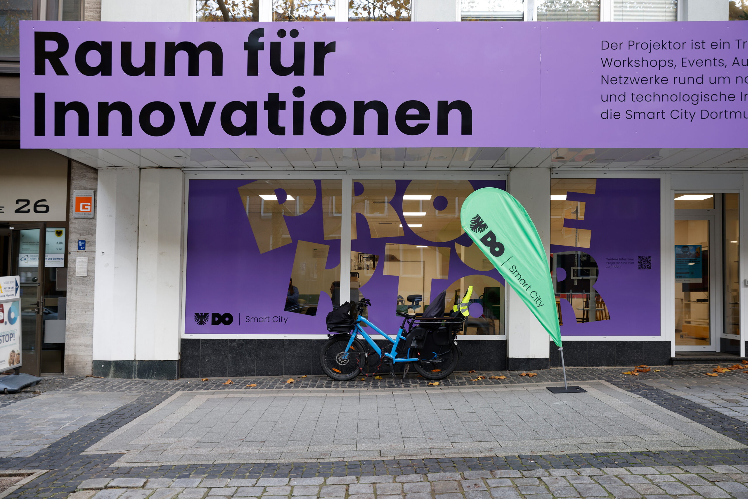 B_51120-scaled Mann steht neben einem Optimus Prime Roboter, der auf einem Tisch platziert ist.